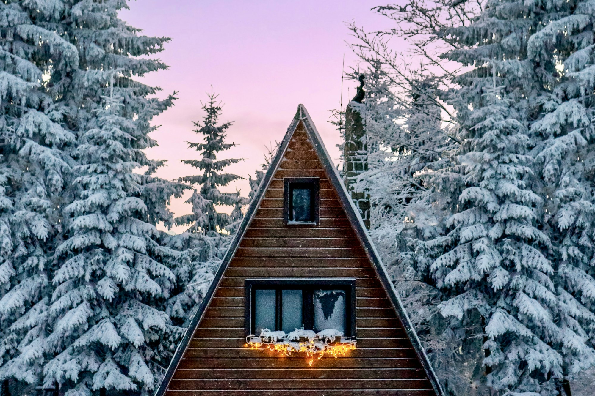 Kleine Hütte mitten im verschneiten Nadelwald